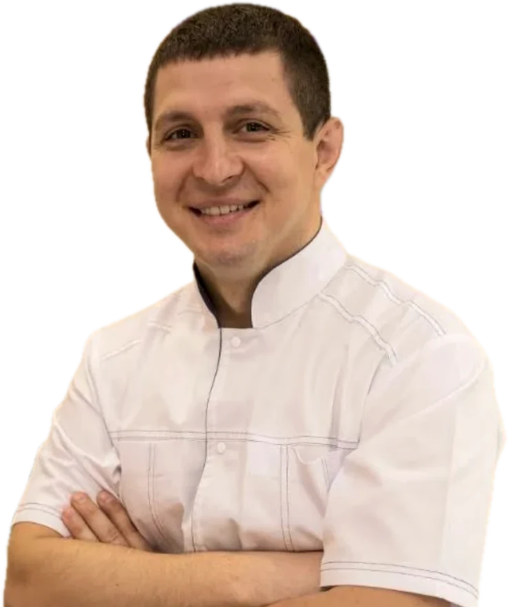 Dr Sergei, principal dentist at Hale, smiling with his arms crossed